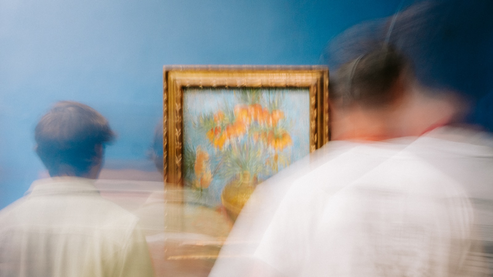 Visitors in front of a gold-framed painting in a gallery